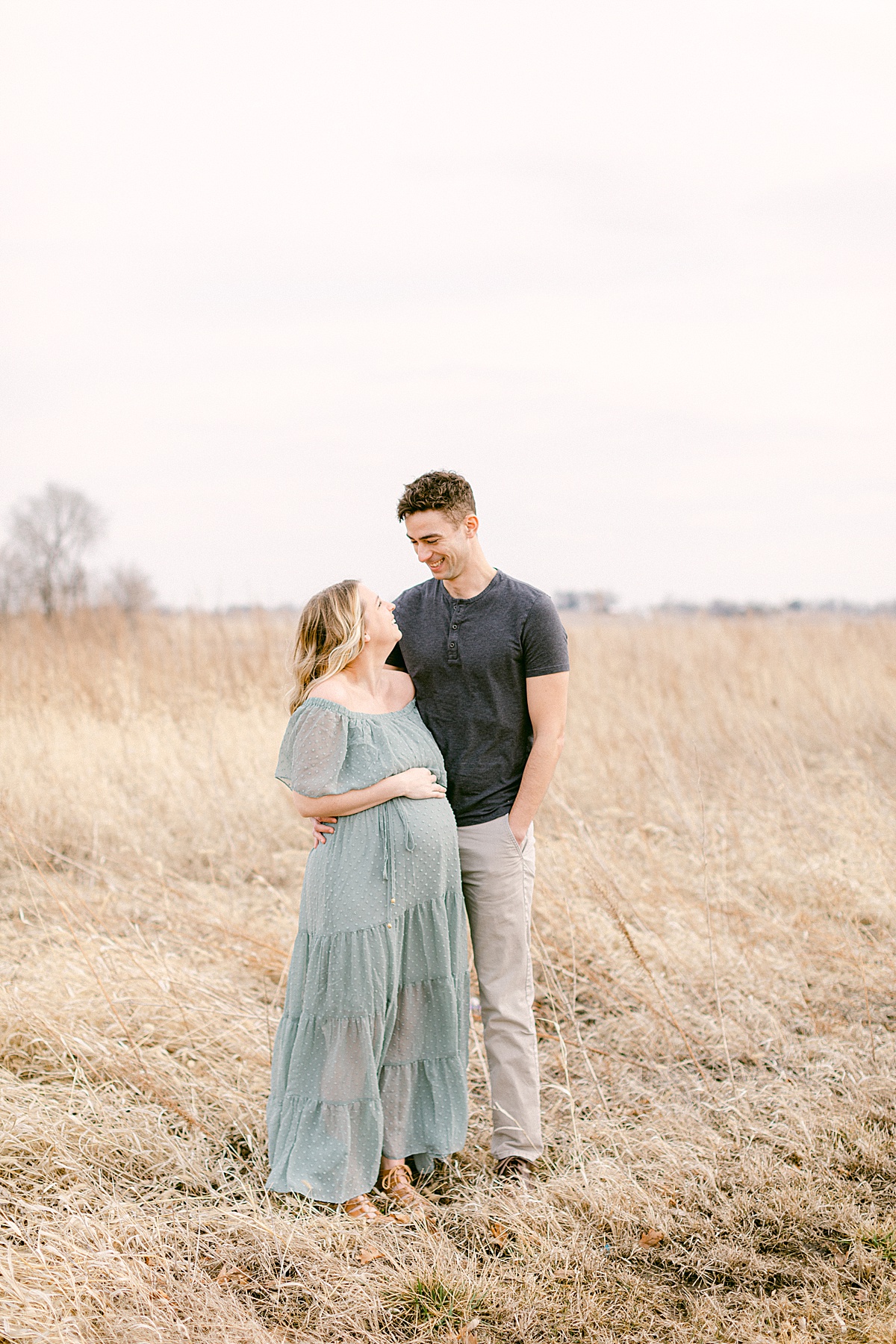 pregnant maternity couple posing in field